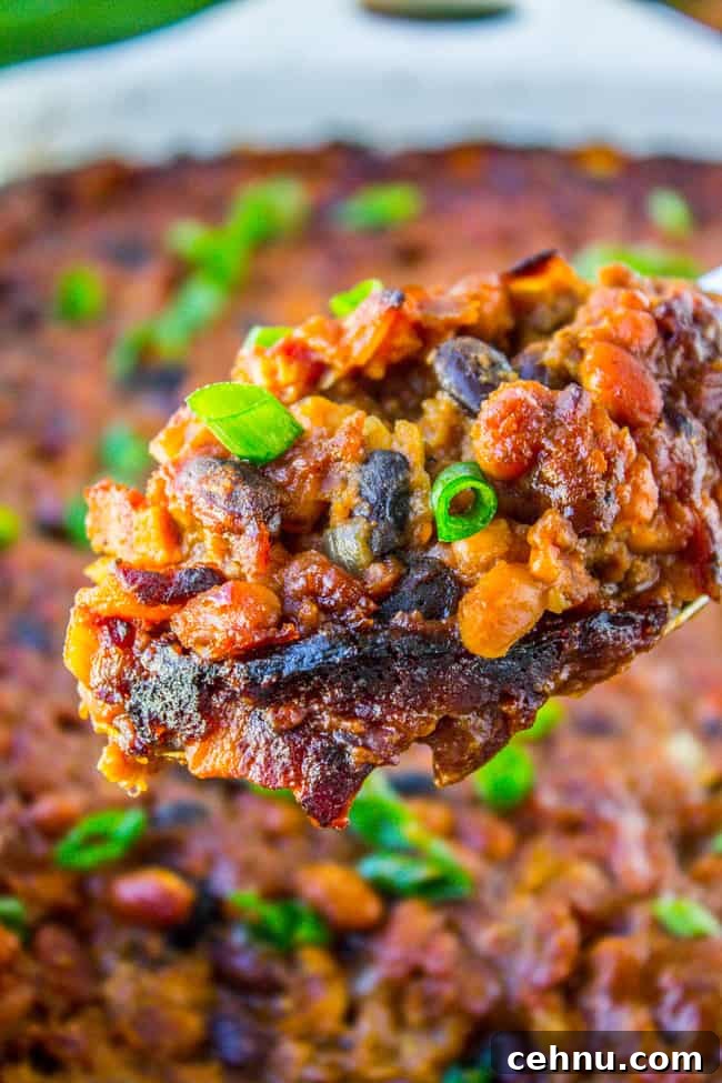 Smoky Baked Beans with Bacon Recipe 2 a serving spoon full of bacon baked beans.
