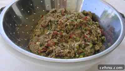 Drain meat mix in colander for greek recipe keftedakia kalokairinoi.