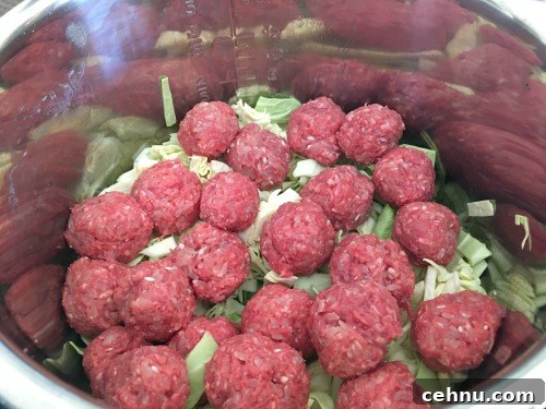 Raw meatballs on top of cabbage in an Instant Pot.