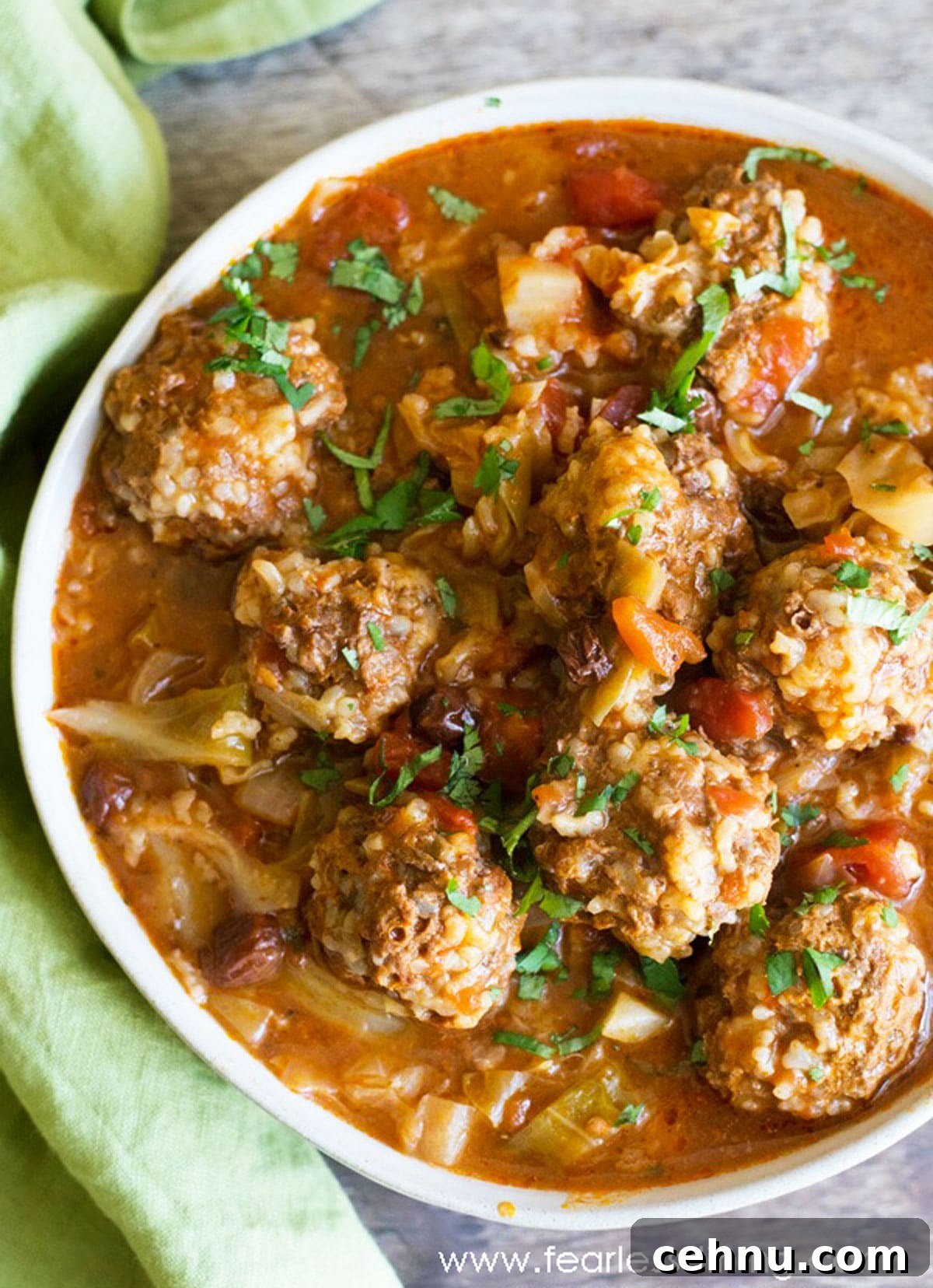 The top view of a serving dish filled with cabbage and meatballs.