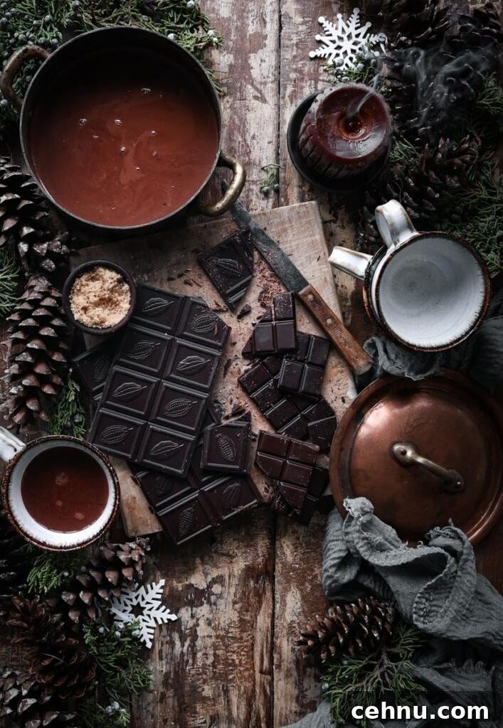 Authentic French Hot Chocolate Recipe 3 Chopped dark chocolate on cutting board next to pot of hot chocolate on table.
