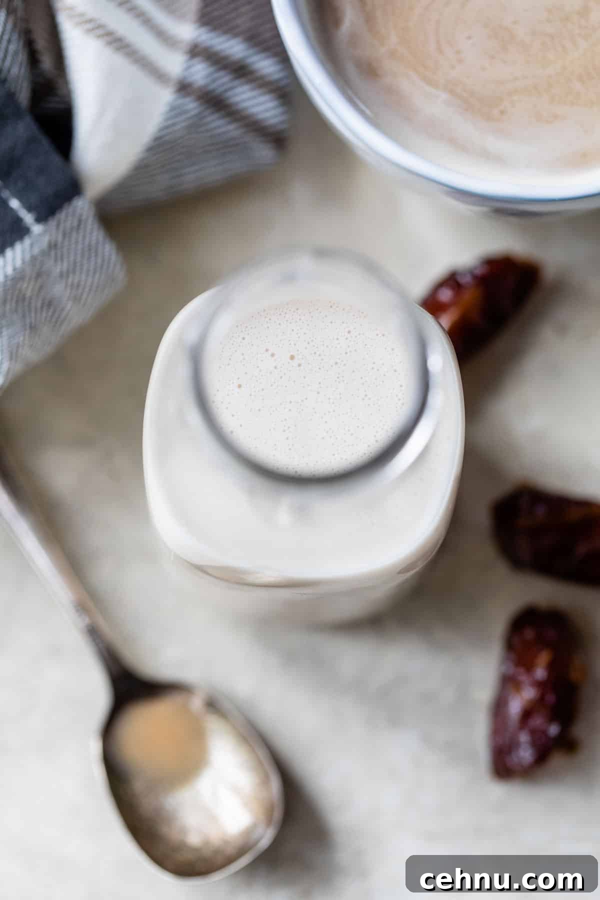 coffee creamer in a jar beside a mug of coffee and two dates