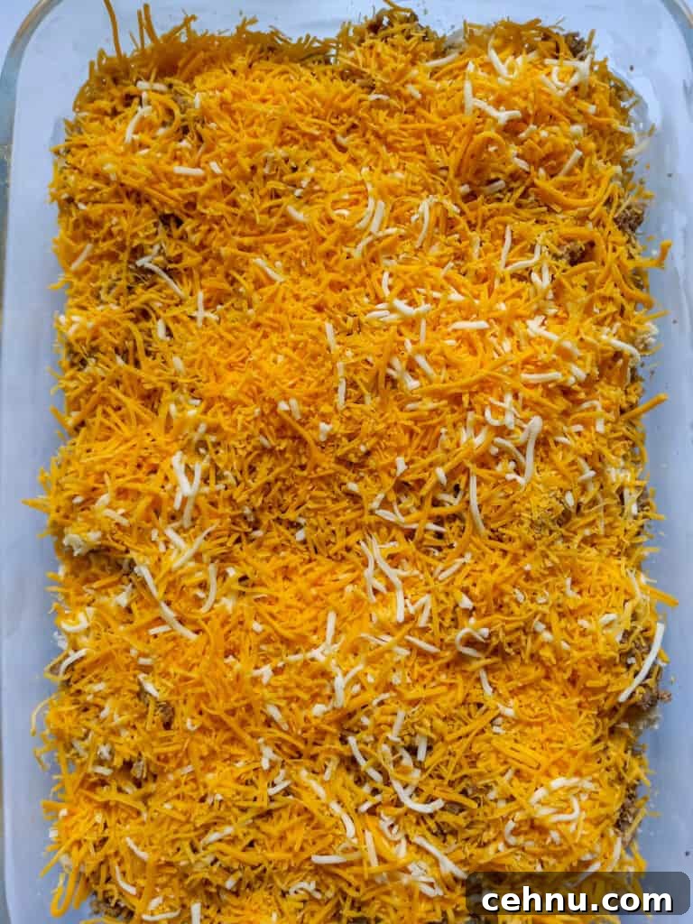 bread cubes, meat, and cheese spread into pan