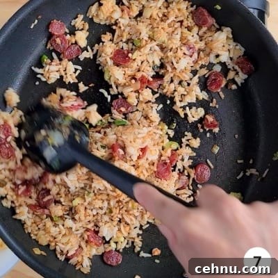 Stir frying of fried rice in a large pan with a black spatula