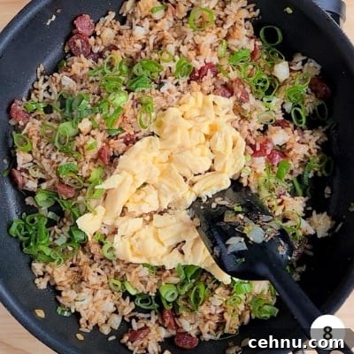 Scrambled eggs added back into pan along with thinly sliced green parts of spring onion/scallion