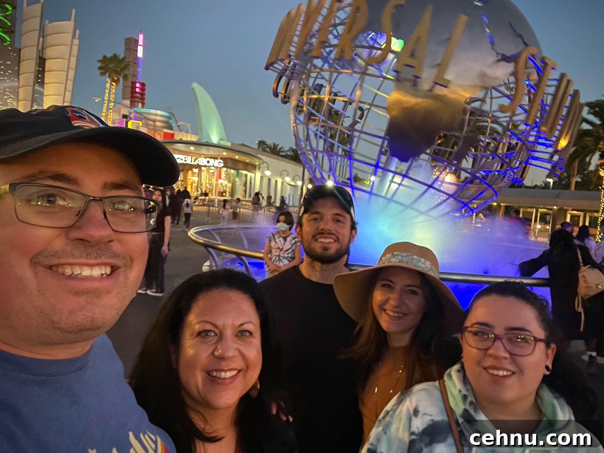 Lets Get Lost February 2022 Travel Inspiration 20 Steve and Rebecca Blackwell and their daughters, Kate and Anne, and Anne's boyfriend Scott standing in front of a large globe of the earth in Universal Studios, California.