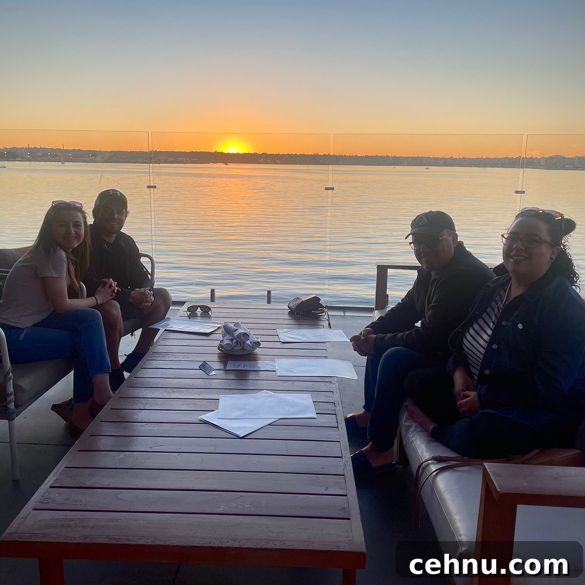 Lets Get Lost February 2022 Travel Inspiration 6 Steve, Kate, and Anne Blackwell and Anne's boyfriend Scott sitting outside on a rooftop patio overlooking the ocean in San Diego.