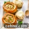 15+ Homemade Soup Recipes for Cozy Weeknight Meals 21 Two bread bowls of cheeseburger soup on a white serving platter.