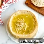 15+ Homemade Soup Recipes for Cozy Weeknight Meals 22 Sourdough bread bowl filled with soup on a white plate.