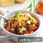 15+ Homemade Soup Recipes for Cozy Weeknight Meals 9 Soup bowl filled with homemade stovetop chili, garnished with shredded cheddar cheese and chopped scallions.