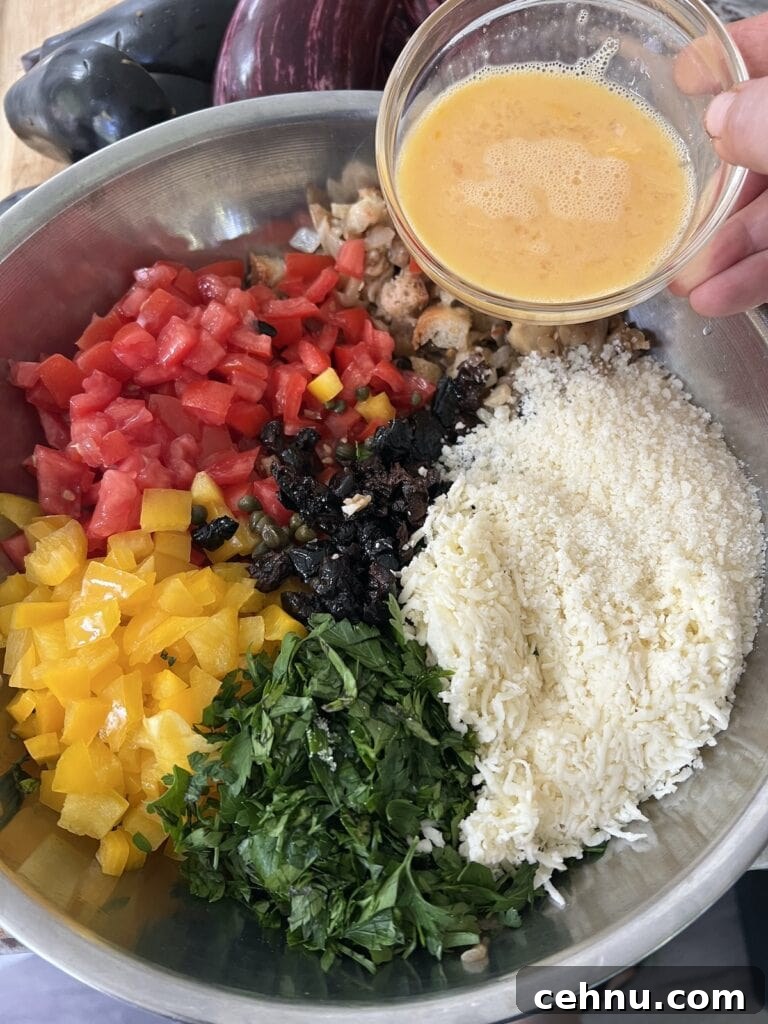 Making the eggplant filling by mixing together the sautéed eggplant pulp with the remaining veggies, cheese and egg.