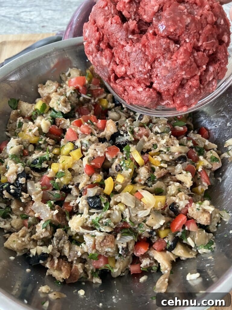 Adding ground beef to the filling to finish the eggplant stuffing mixture.