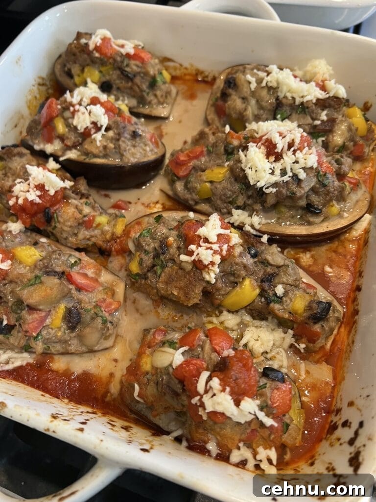 Some shredded mozzarella sprinkled over the roasted stuffed eggplant, ready to go under the broiler.