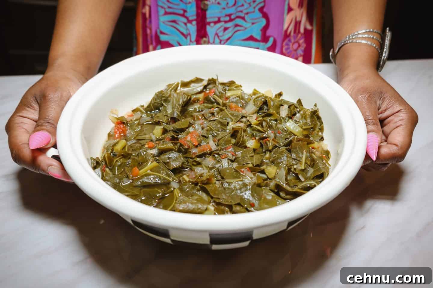 How to know when collard greens are done - Soul food expert Shaunda Necole holds a bowl of Southern soul food collard greens, ready to serve, featuring tender greens braised in pot likker. A comforting, flavorful side dish rooted in African American home cooking traditions.