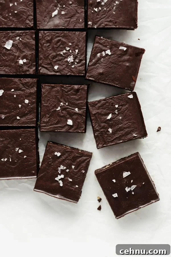 a top down image of raw chocolate brownies cut into squares on a piece of parchment paper