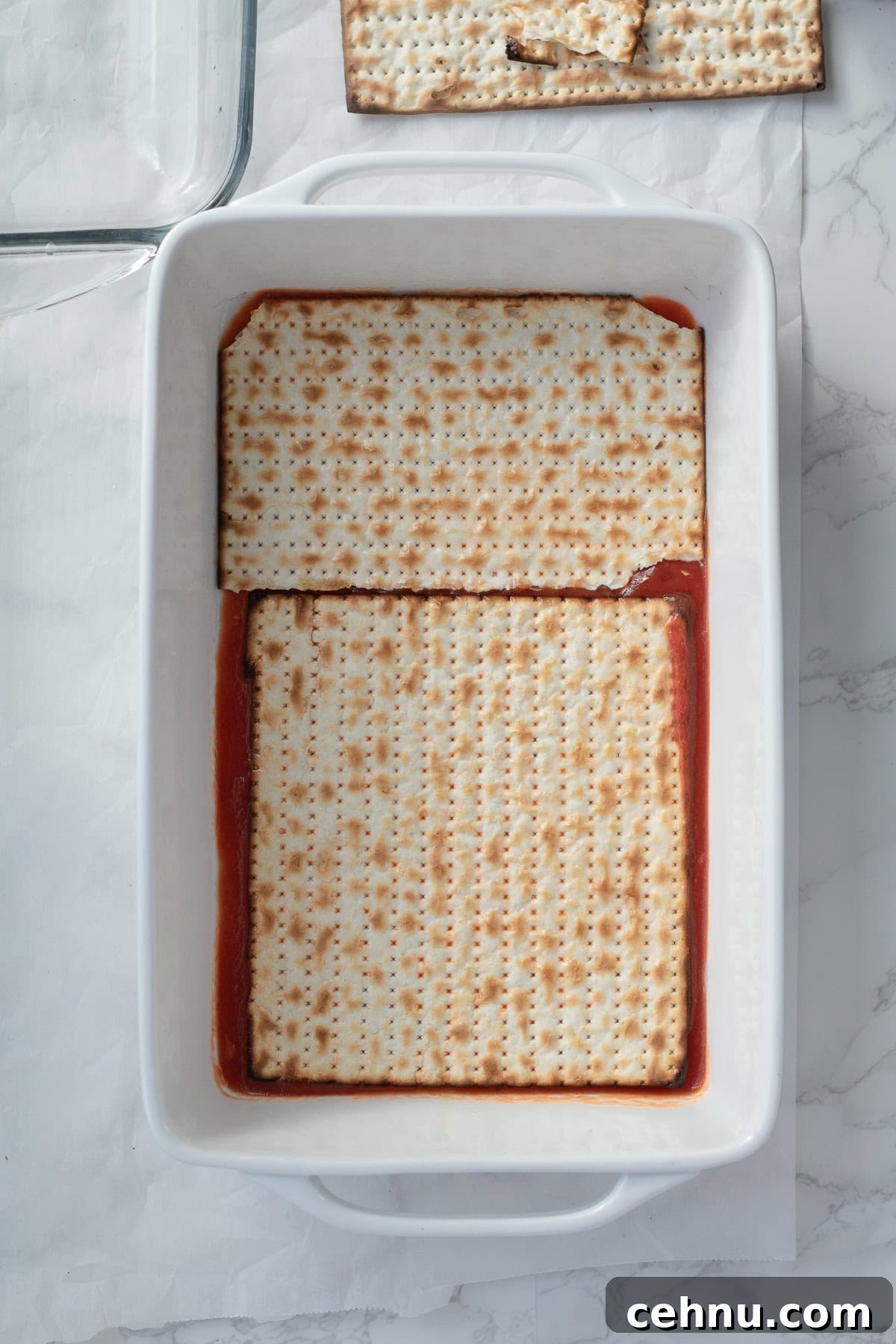 5-Ingredient Matzo Lasagna for Passover Dinner 6 matzo pieces in a baking dish over pasta sauce