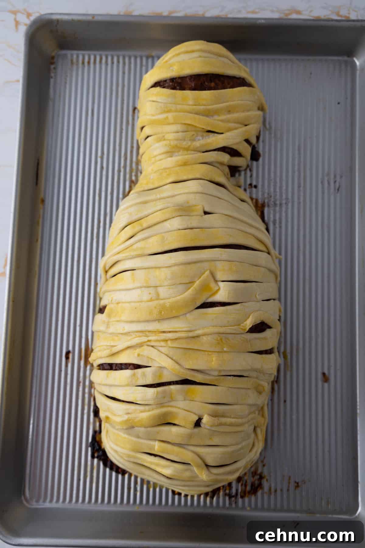 Halloween Mummy Meatloaf Recipe 13 Mummy meatloaf wrapped with puff pastry strips.