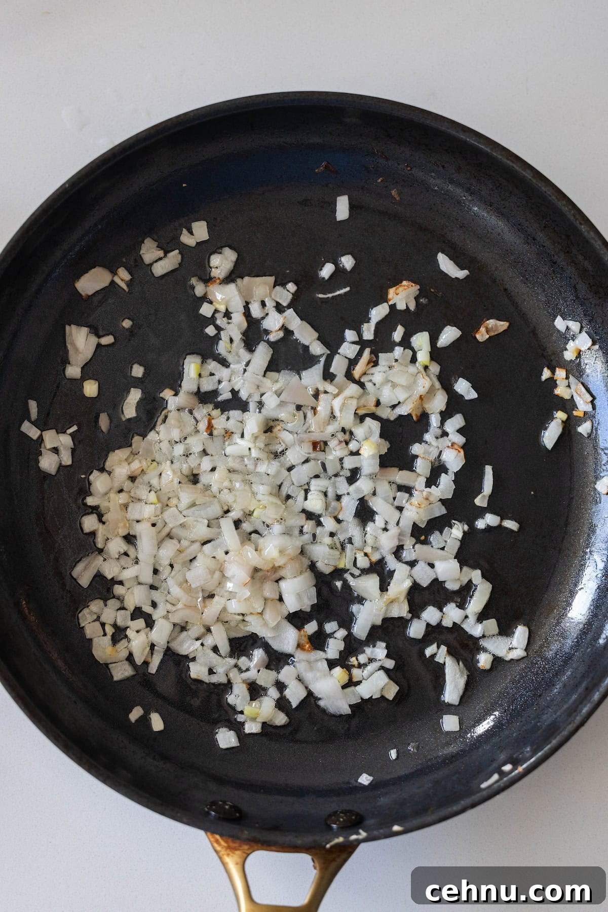 Halloween Mummy Meatloaf Recipe 6 Chopped onions sautéing in a skillet.