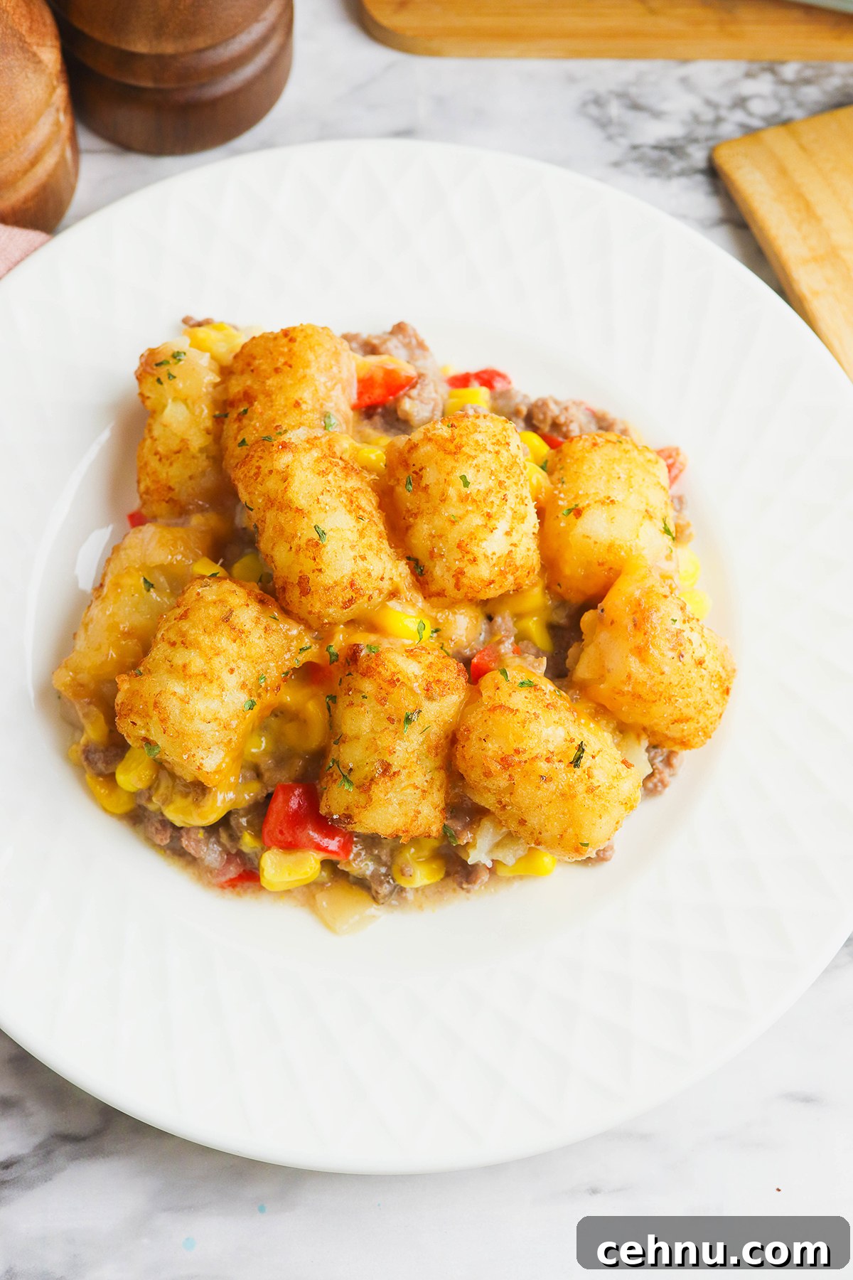 Cheesy Tater Tot Casserole with Ground Beef Recipe 11 Serving of Tater Tot Casserole on round white plate.