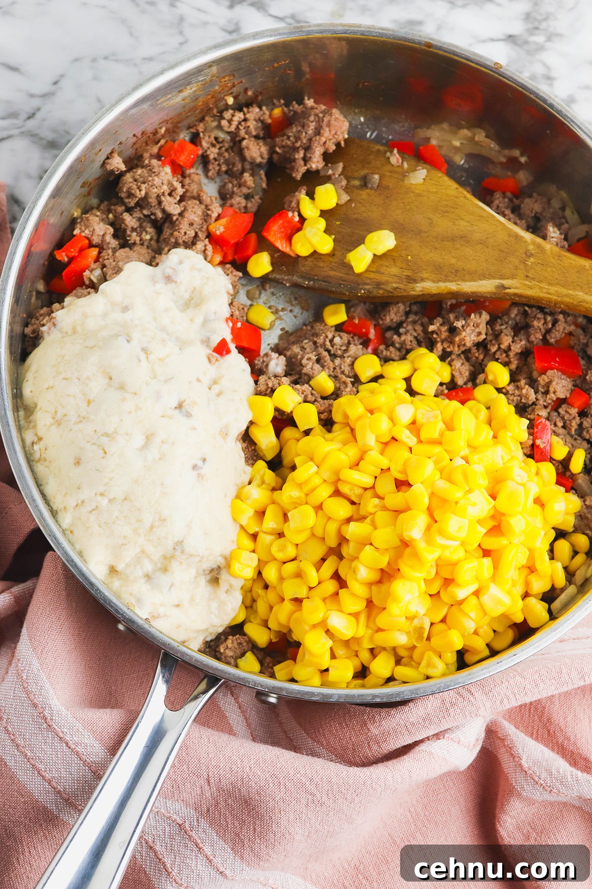 Cheesy Tater Tot Casserole with Ground Beef Recipe 6 Corn and cream of mushroom soup added to ground beef in saucepan.