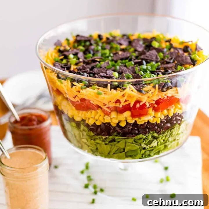 Layered taco salad in a clear dish.