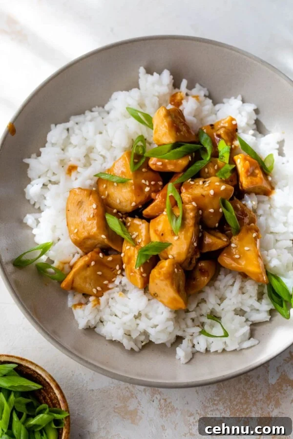 orange chicken on top of rice in a bowl