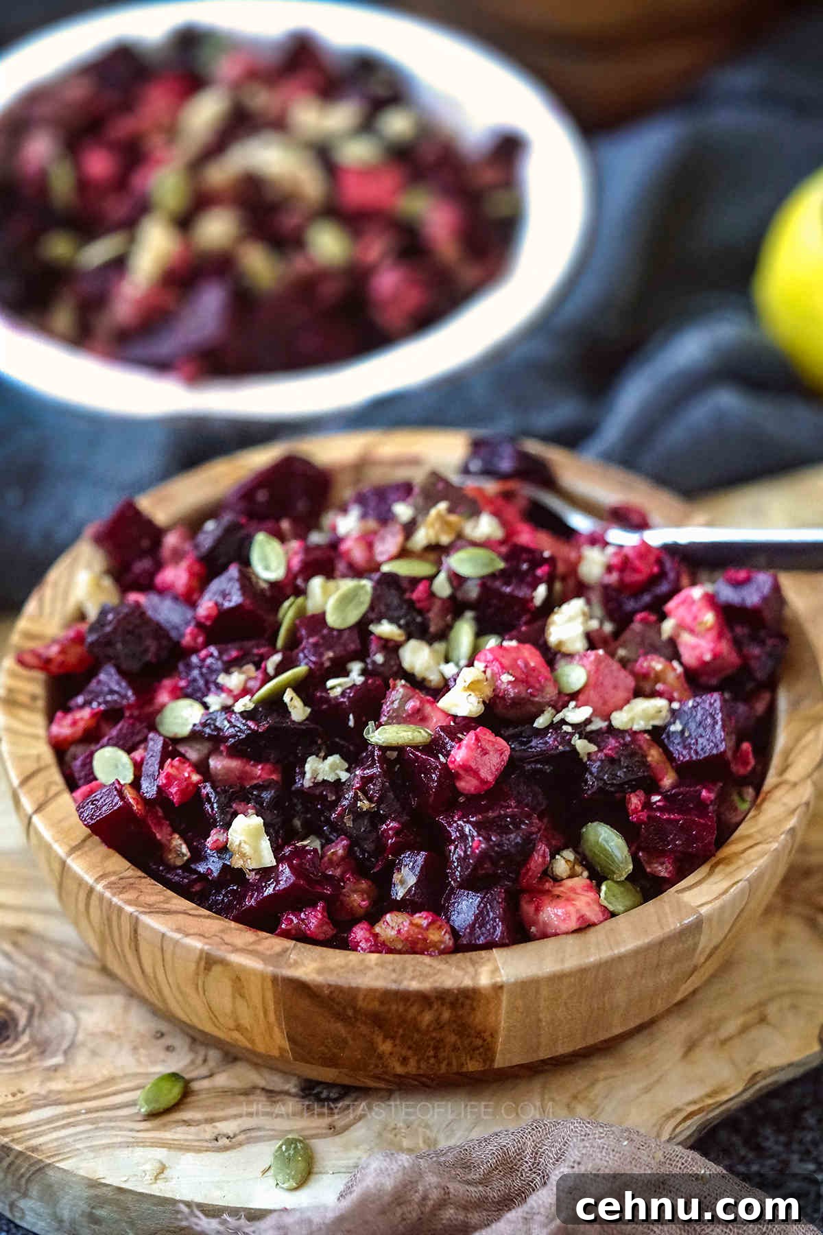 Vegan salad with beetroot, walnuts, prunes and avocado garnished with pumpkin seeds.
