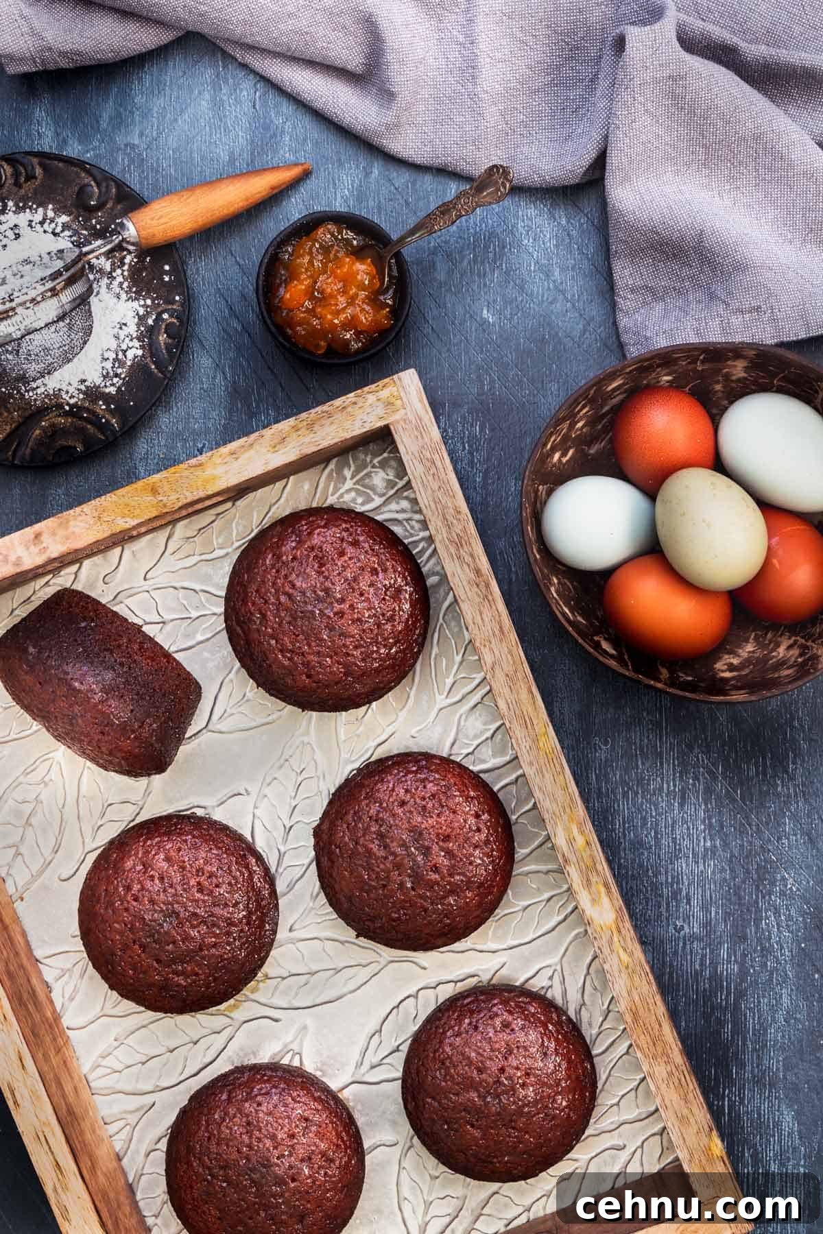 Authentic South African Malva Pudding Cake Recipe 7 Malva pudding cakes in a wooden tray with eggs and jam