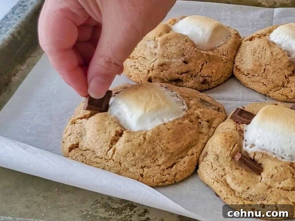 Chewy Gluten Free Smores Cookies Recipe 11 pushing chocolate pieces into warm cookies after baked.