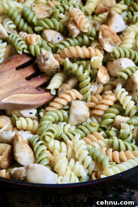 add cooked pasta to skillet with chicken