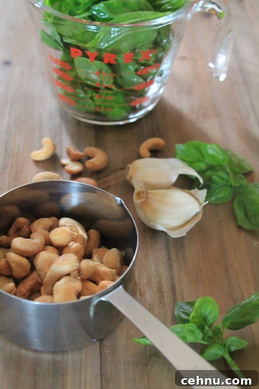 basil pesto ingredients with cashews, garlic, basil, parmesan, and olive oil