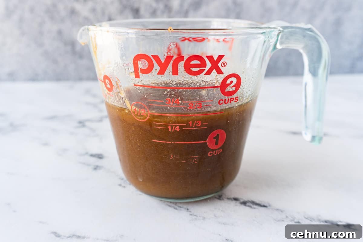 melted butter, brown sugar, and cinnamon mixed together in a clear Pyrex measuring cup.