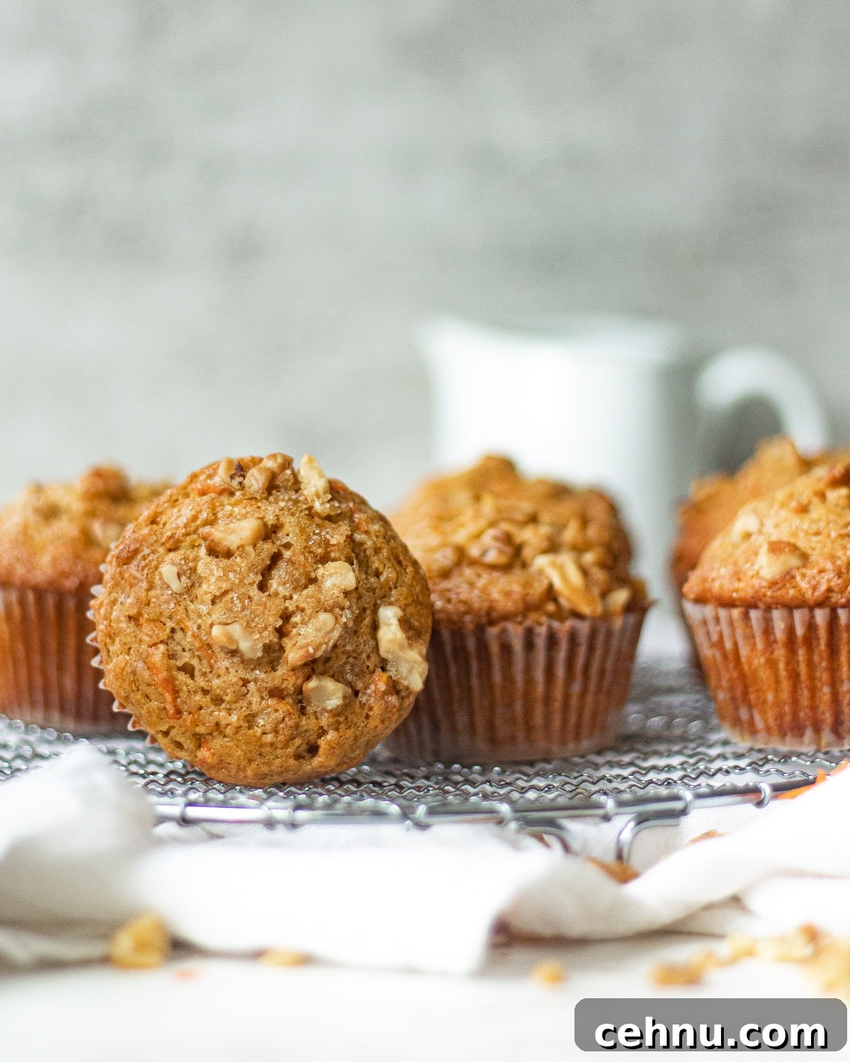 Moist Banana Carrot Muffins 8 banana carrot muffins on a rack -- one is on its side