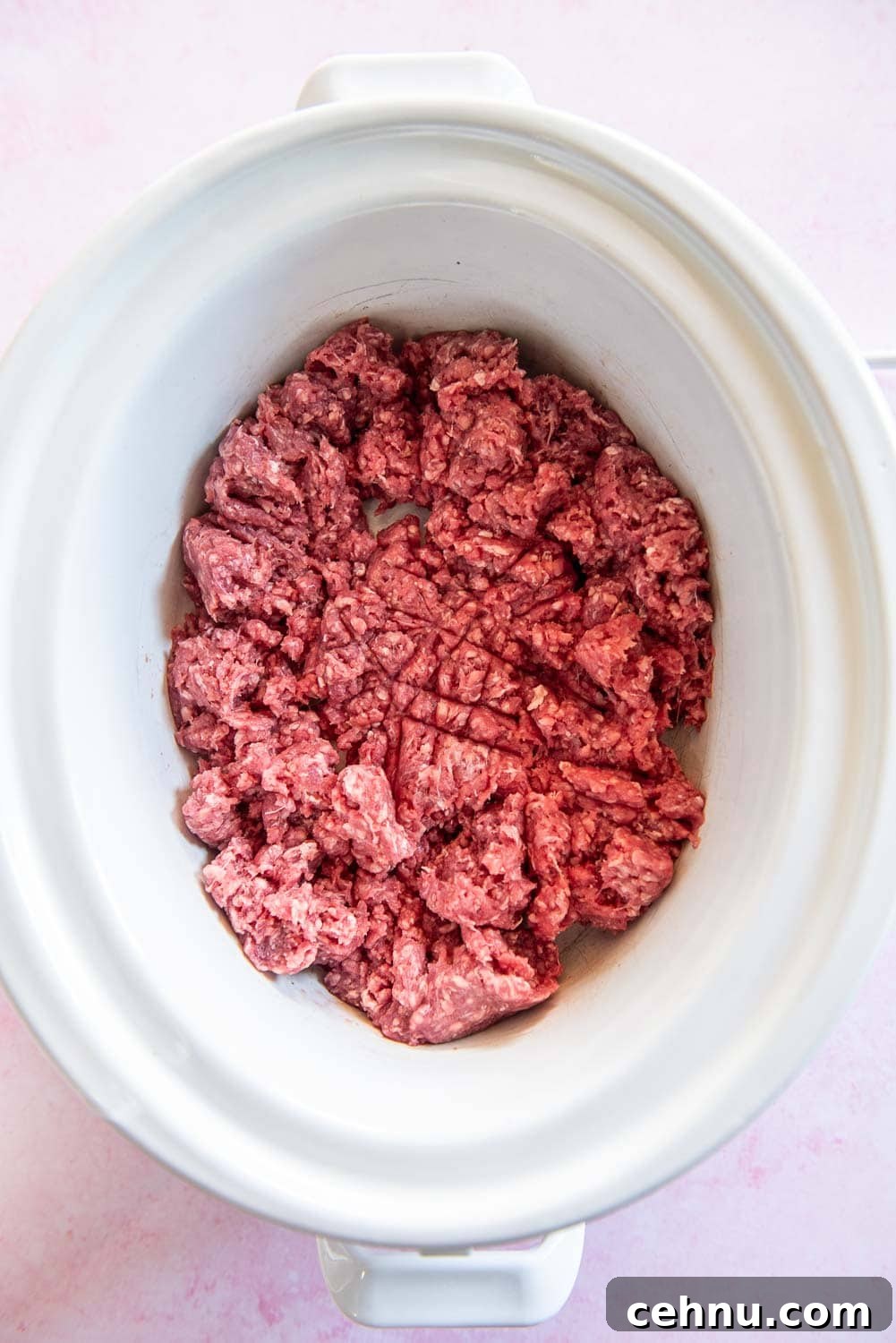Slow Cooker Taco Meat Recipe: Tender, Flavorful Filling 5 raw ground beef broken apart inside of white slow cooker bowl