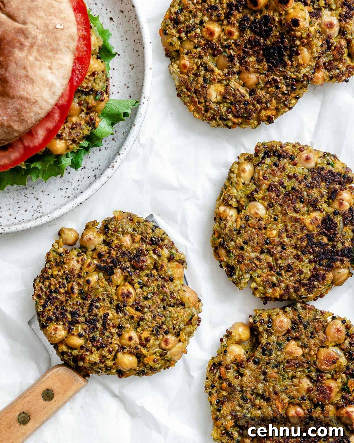 completed Quinoa Chickpea Patties on a white surface alongside a burger