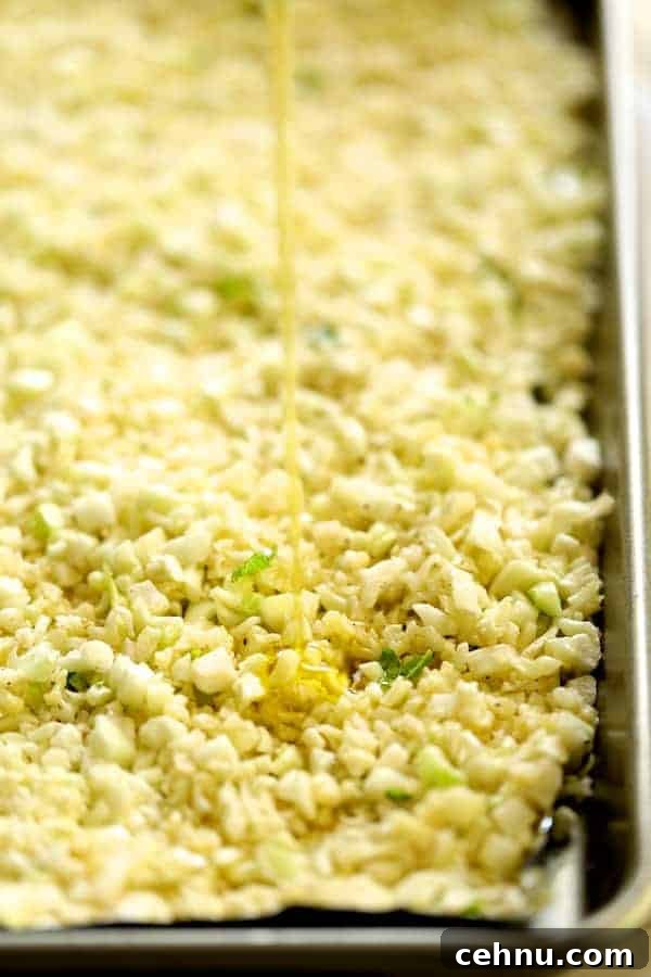 Slow Cooker Barbacoa Short Ribs with Cilantro-Lime Cauli Rice 6 Photo of cauliflower rice being drizzled with oil on sheet pan before roasting.