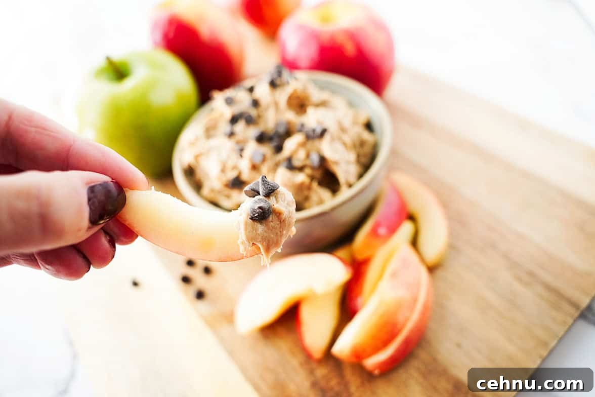 hand holding apple slice with apple toffee dip