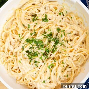 Cajun fettuccine Alfredo in a large skillet garnished with fresh parsley.