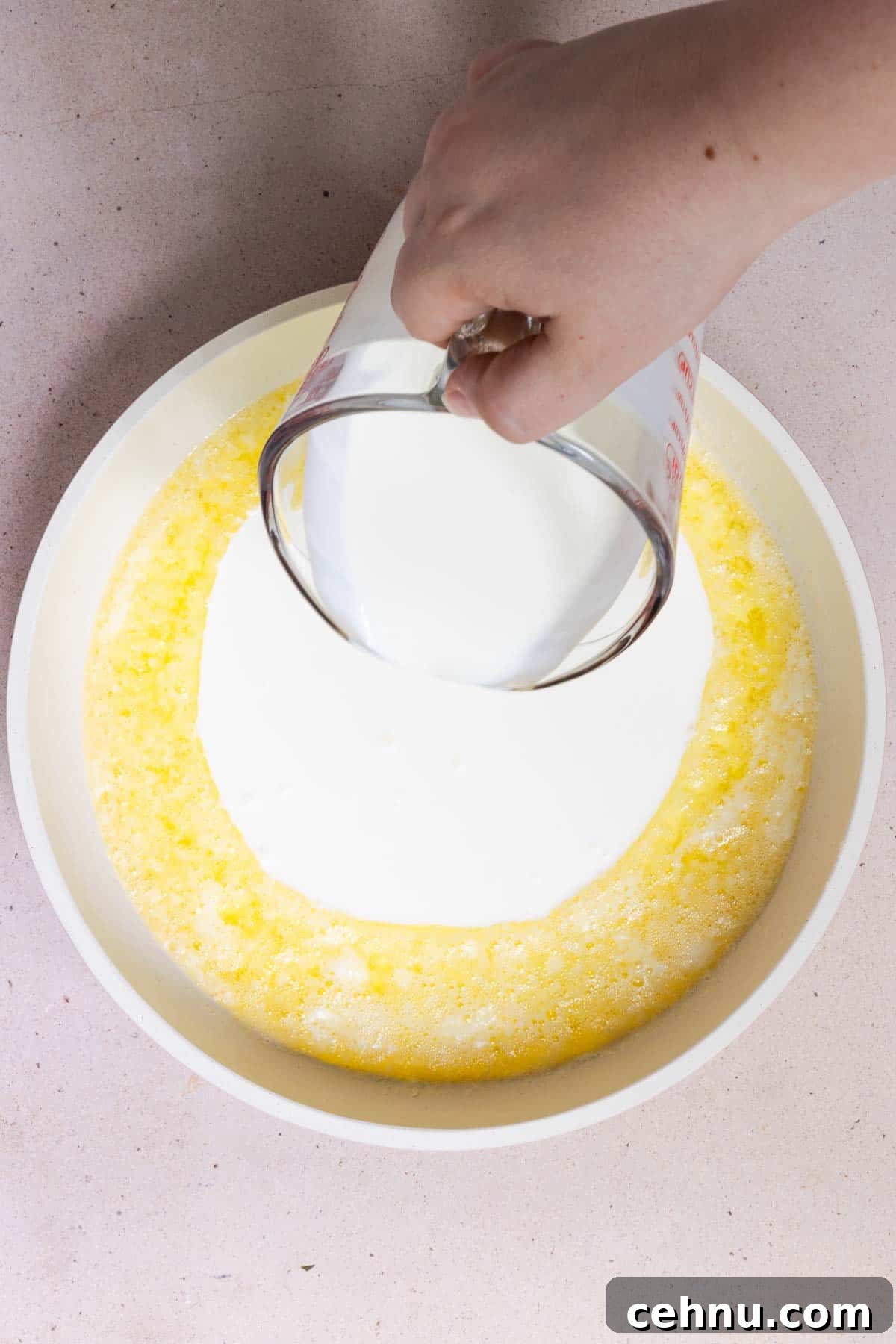 Heavy cream poured into melted butter in a large skillet.