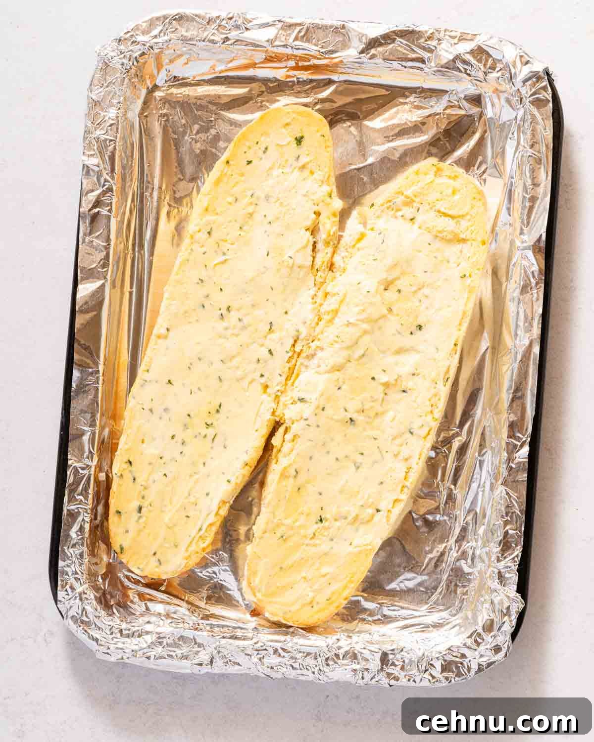 Garlic Bread Sloppy Joes Recipe for Cheesy Saucy Sandwiches 4 uncooked garlic bread on pan covered in tin foil.