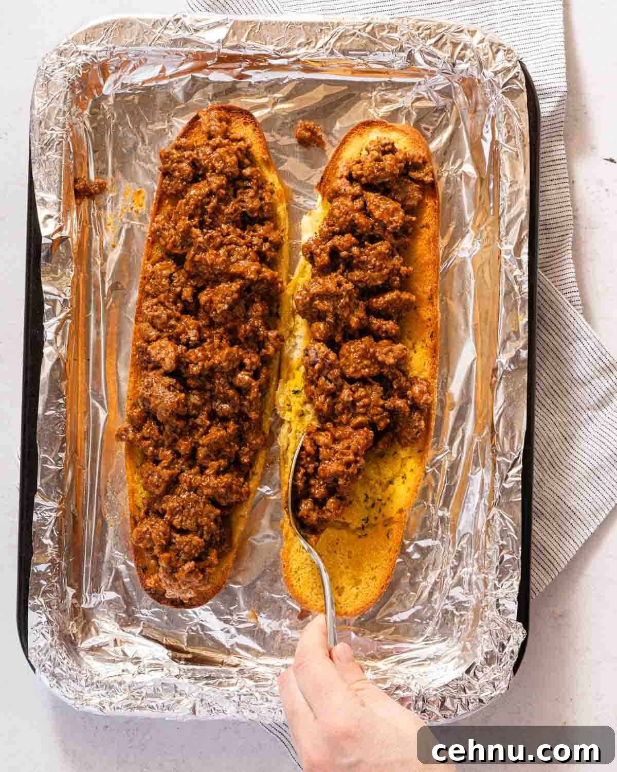 Garlic Bread Sloppy Joes Recipe for Cheesy Saucy Sandwiches 8 two pieces of garlic bread covered with sloppy joe meat.