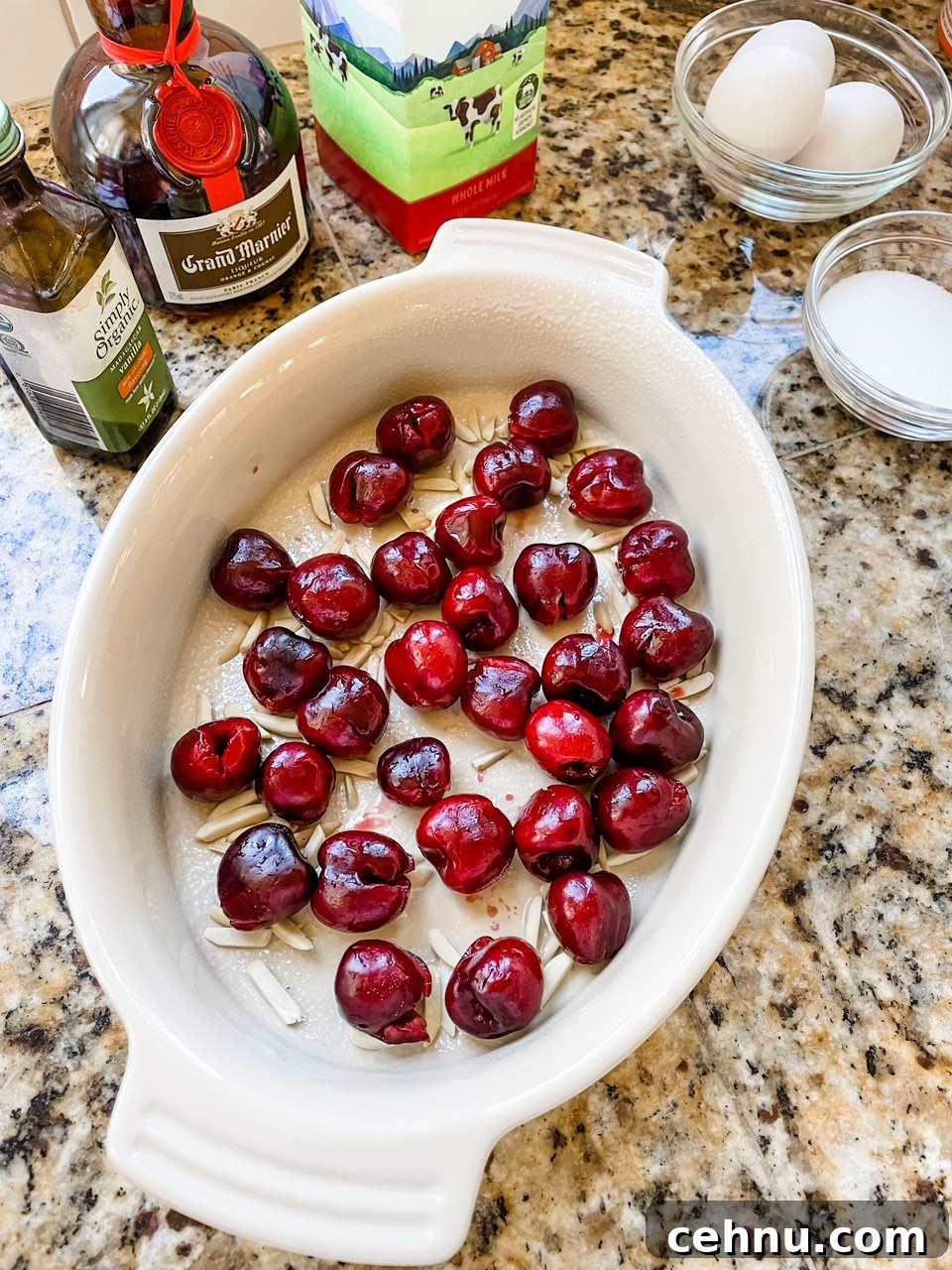 How to Make Fresh Cherry Clafoutis 4 Fresh cherries and slivered almonds lining a baking dish