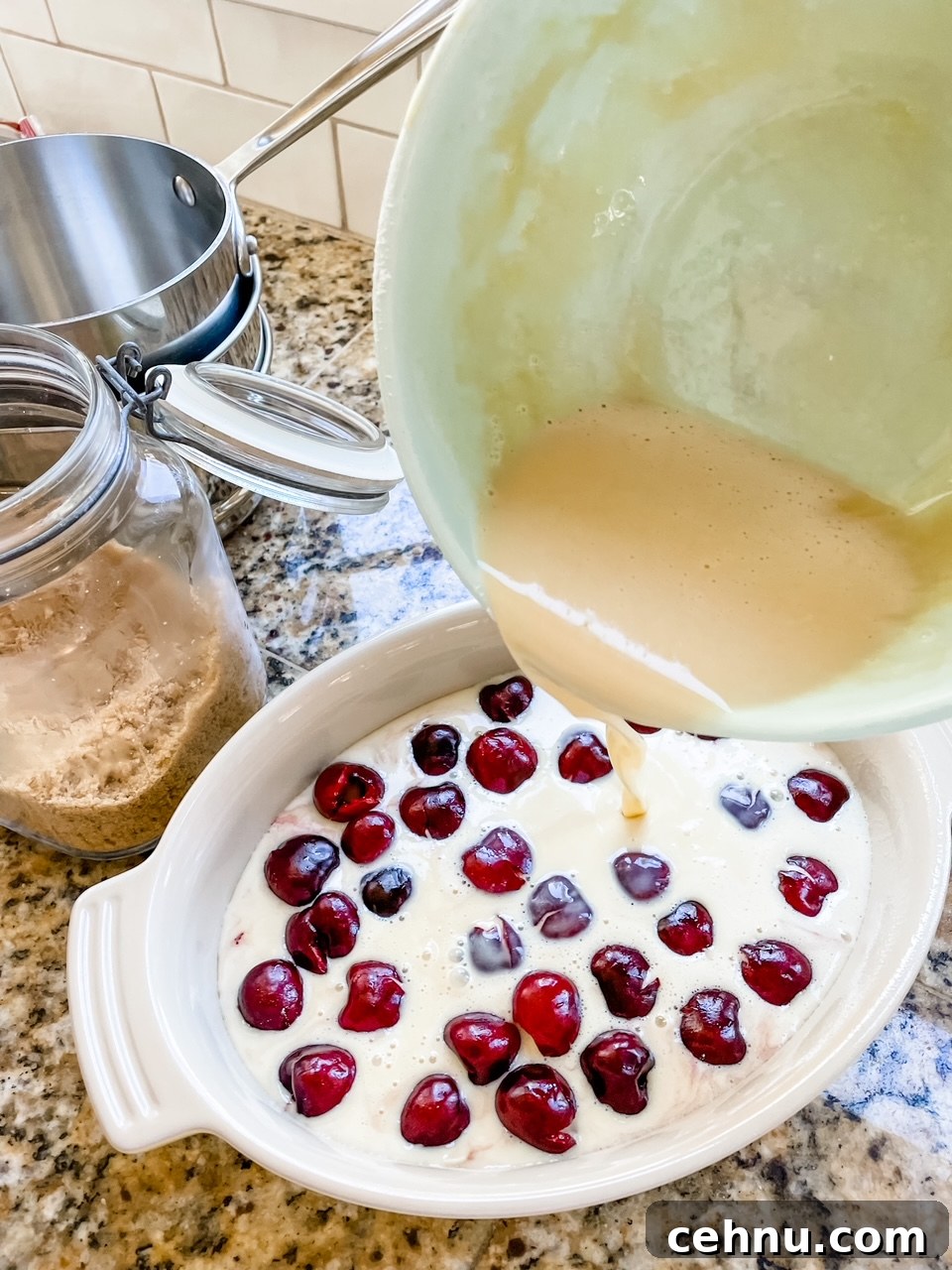 How to Make Fresh Cherry Clafoutis 5 The batter being poured over the baking dish filled with cherries