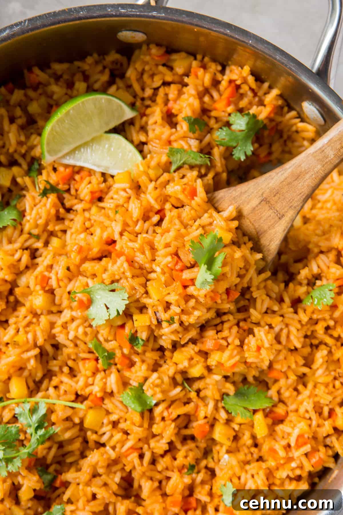 Authentic Restaurant-Style Mexican Rice Recipe 4 A top down shot of a spoon scooping Mexican rice from a skillet.
