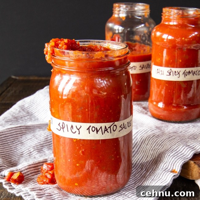 Three jars labeled spicy tomato sauce with a little dripping over the side.