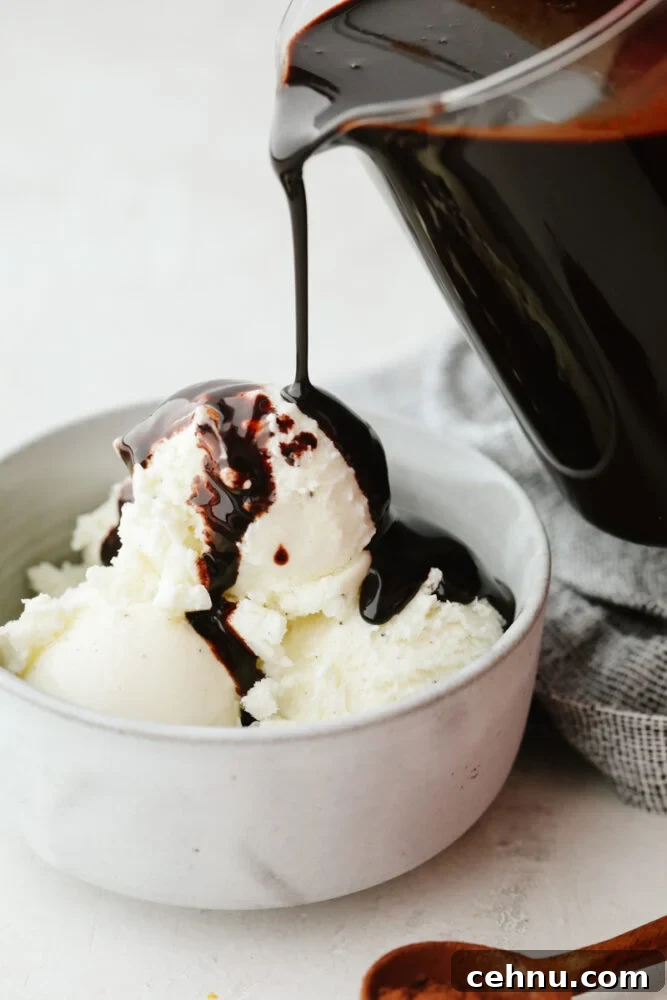 This homemade chocolate sauce has the perfect chocolate flavor and the smooth texture is to die for. It goes on just about anything and is so simple to make! Chocolate sauce being poured onto some vanilla ice cream.