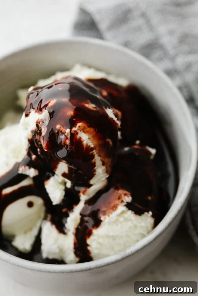This homemade chocolate sauce has the perfect chocolate flavor and the smooth texture is to die for. It goes on just about anything and is so simple to make! Ice cream in a bowl with chocolate sauce.