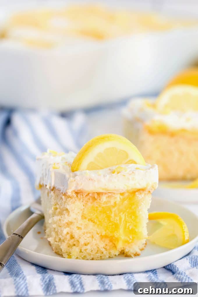 A piece of lemon poke cake on a white plate.