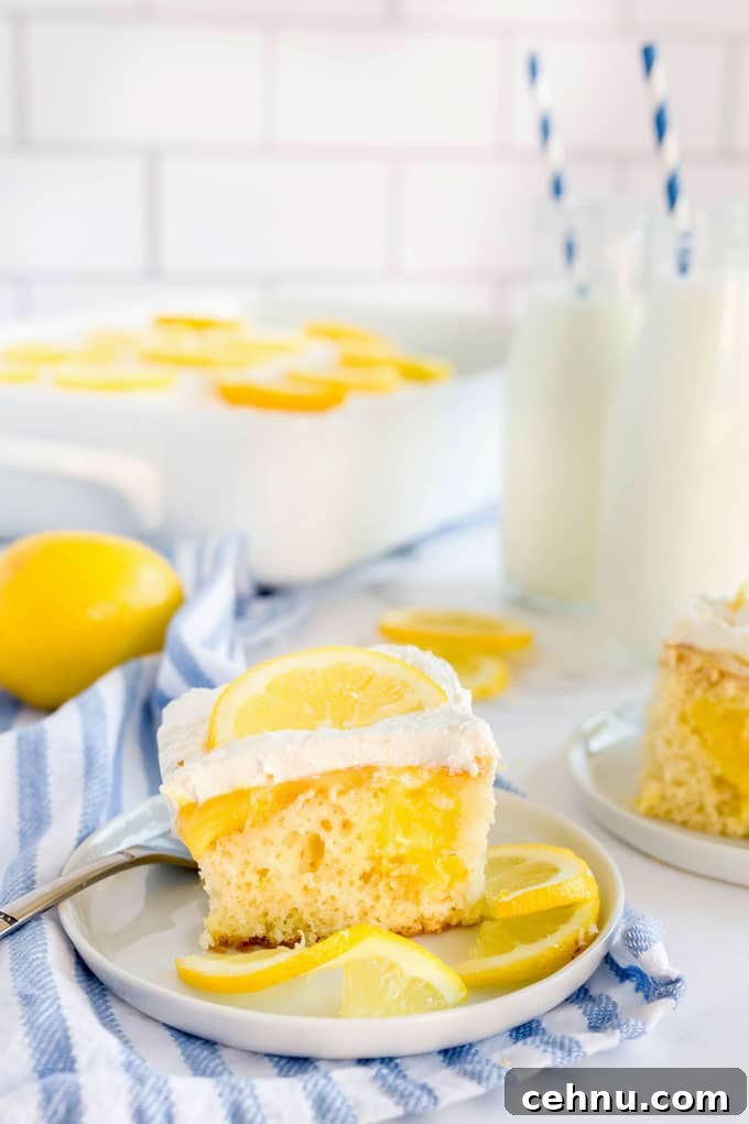 A piece of lemon poke cake on a white plate.