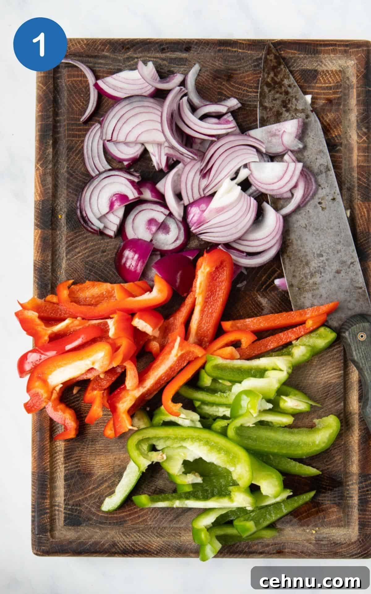 Chopped red onions, red pepper and green pepper on a chopping board.